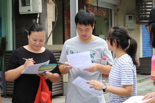 8月11日生命与环境科学学院赴余杭区社区五水共治教育宣传小分队 认真阅读问卷的路人