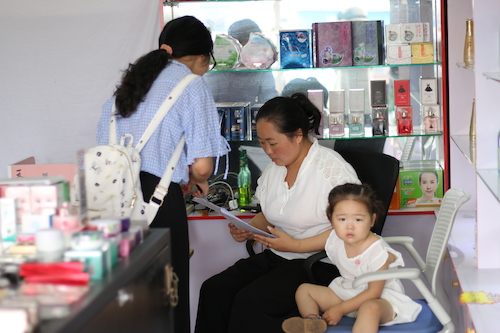 8月11日生命与环境科学学院赴余杭区社区五水共治教育宣传小分队 与化妆品店老板说明问卷内容